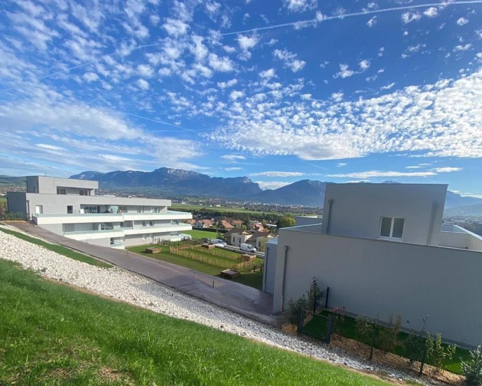 a white building with a view of the mountains at Appartement Mont-Blanc - 3 étoiles in Gillon