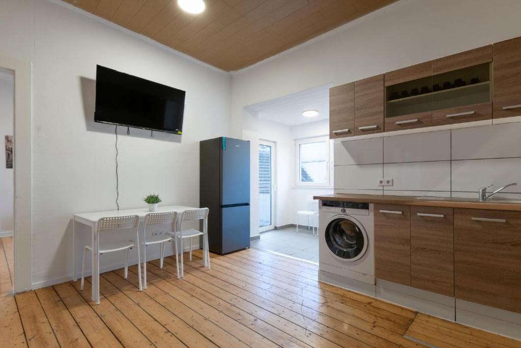 uma cozinha com uma mesa e uma máquina de lavar roupa em T&K Apartments - Duisburg - 4 Rooms Apartment - 2nd Floor em Duisburg
