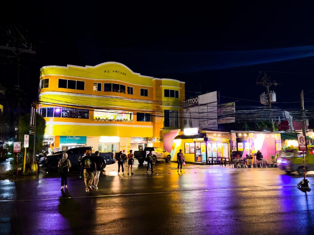 a group of people walking down a street at night at Corazon Tourist Inn in Puerto Princesa City