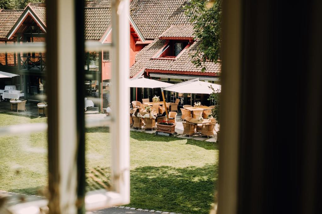 uma janela com vista para um quintal com mesas e guarda-sóis em Engø Gård Hotel & Restaurant em Tjome