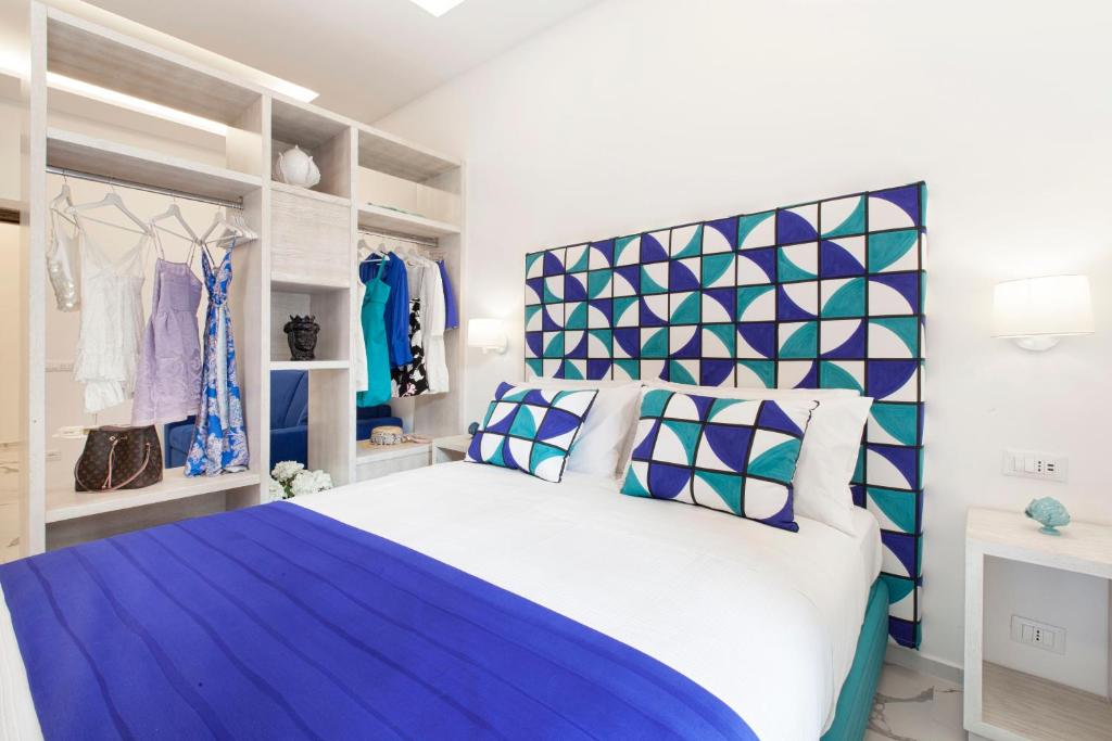 - une chambre dotée d'un grand lit avec des oreillers bleus et blancs dans l'établissement Sorrento Lux Suite, à Sorrente