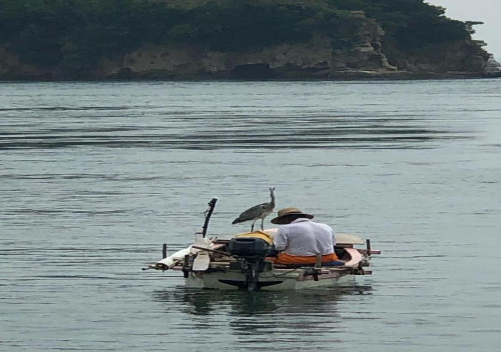 a man sitting in a boat with a bird on it at Guesthouse Yadokari - Vacation STAY 90101 in Imabari