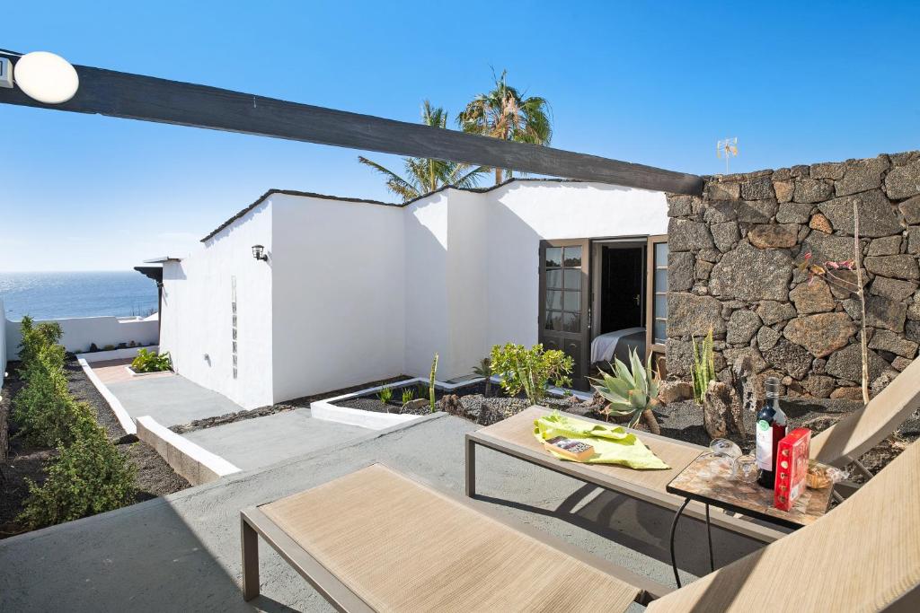 a patio with a table and a stone wall at Casa Los Angeles in Tías