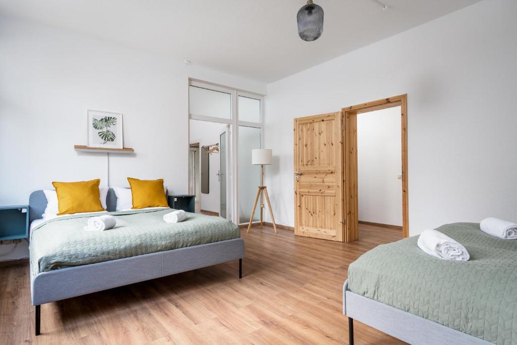 una camera da letto con due letti e pavimento in legno di Ruhig Hell Wohnen im Grünen in Köpenick füßläufig zum Wasser 25min bis Flughafen a Berlino