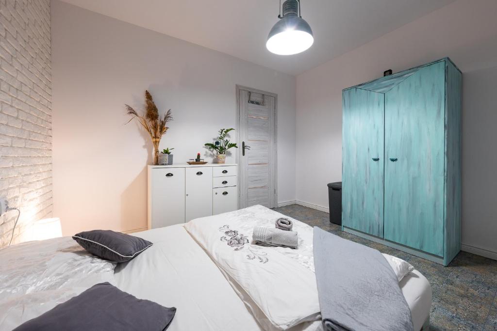 a bedroom with a bed and a blue cabinet at Apartament Południowy in Ruda Śląska