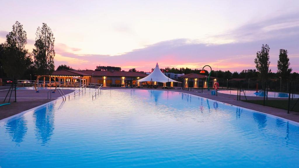 una gran piscina con una tienda de campaña en el fondo en Natura Resorts, en Casalarreina