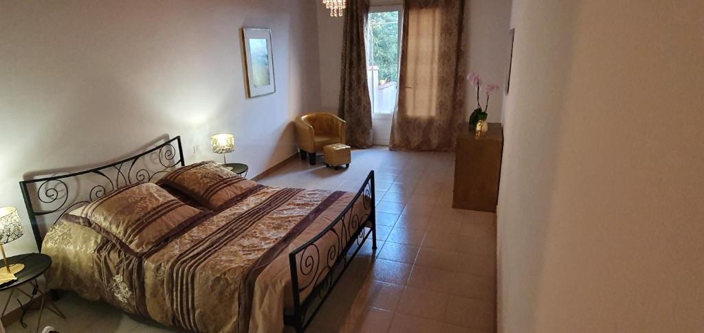 um quarto com uma cama e uma cadeira num quarto em CHEZ ISABELLE em Luri