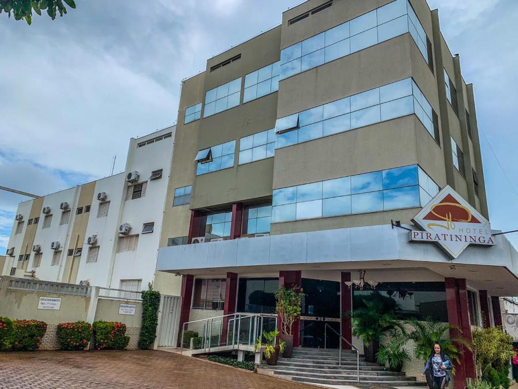 Hotel Piratininga Fernando Corrêa - Rondonópolis في روندونوبوليس: امرأة تقف أمام مبنى