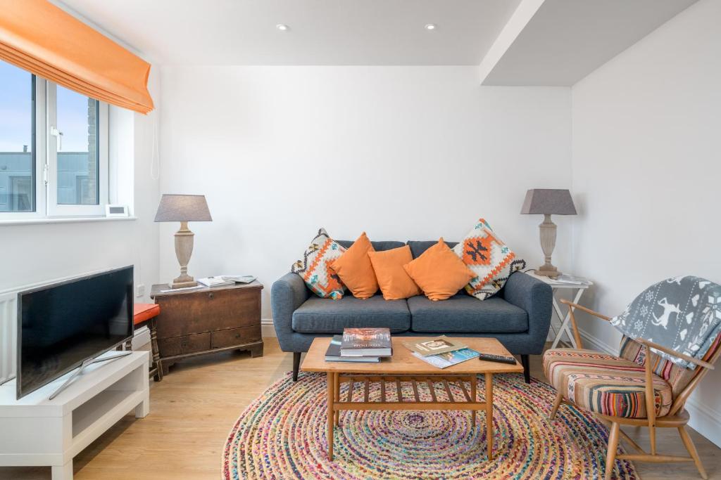 a living room with a couch and a table at ALTIDO Cosy 2 bed, 2 bath flat with terrace, close to Tower Bridge in London