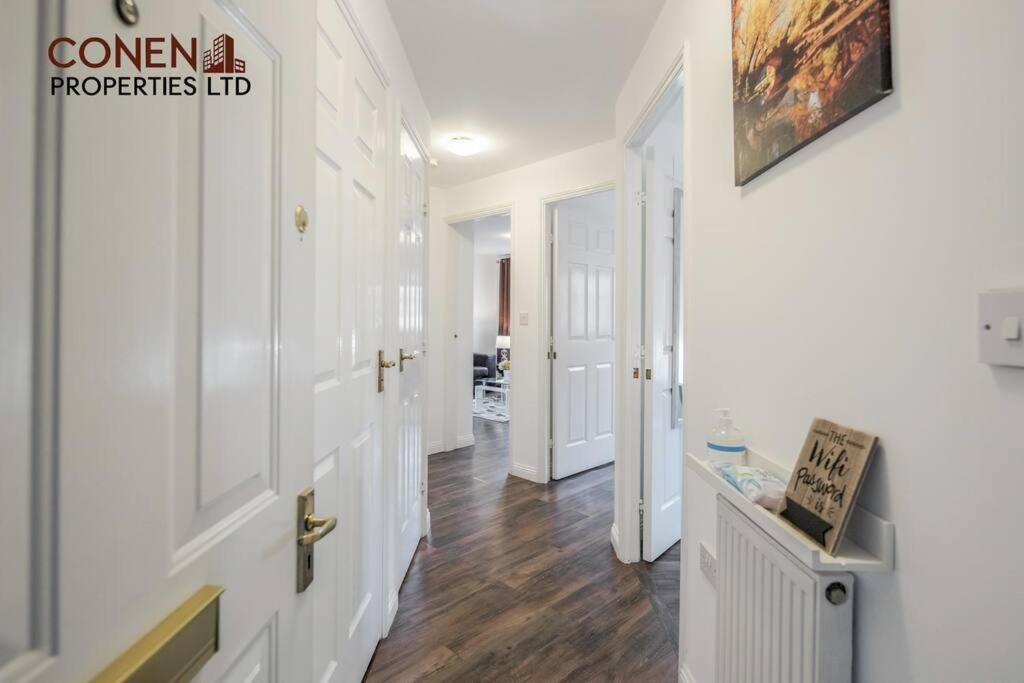 a hallway with white walls and wood floors in a house at CONEN Chafford Three Apartment in West Thurrock