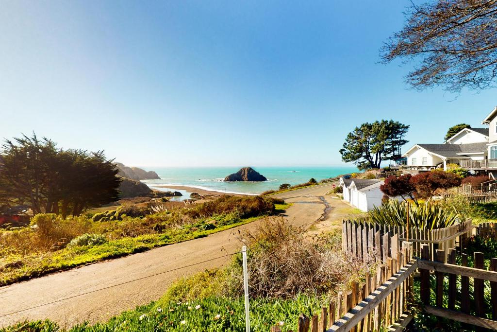 una strada sterrata che porta a una spiaggia con case e l'oceano di Vista de la Playa a Elk