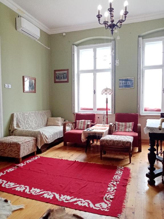 un soggiorno con divano e tappeto rosso di Apartmani Dragulj a Kula