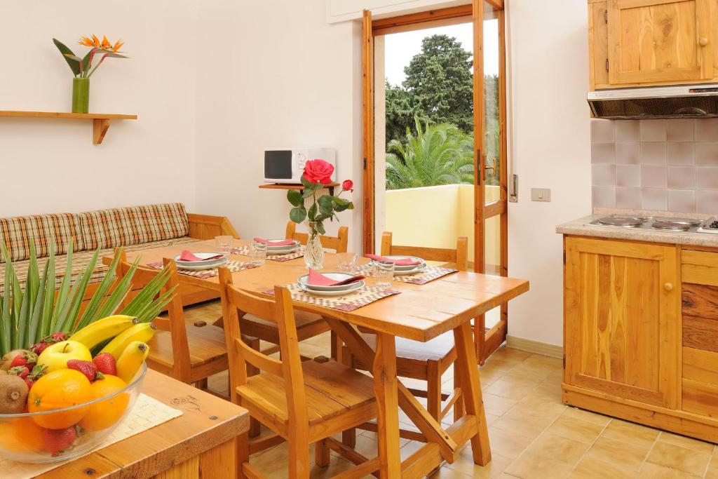 een keuken met een houten tafel en een fruitschaal bij Residence Oasis in Alghero