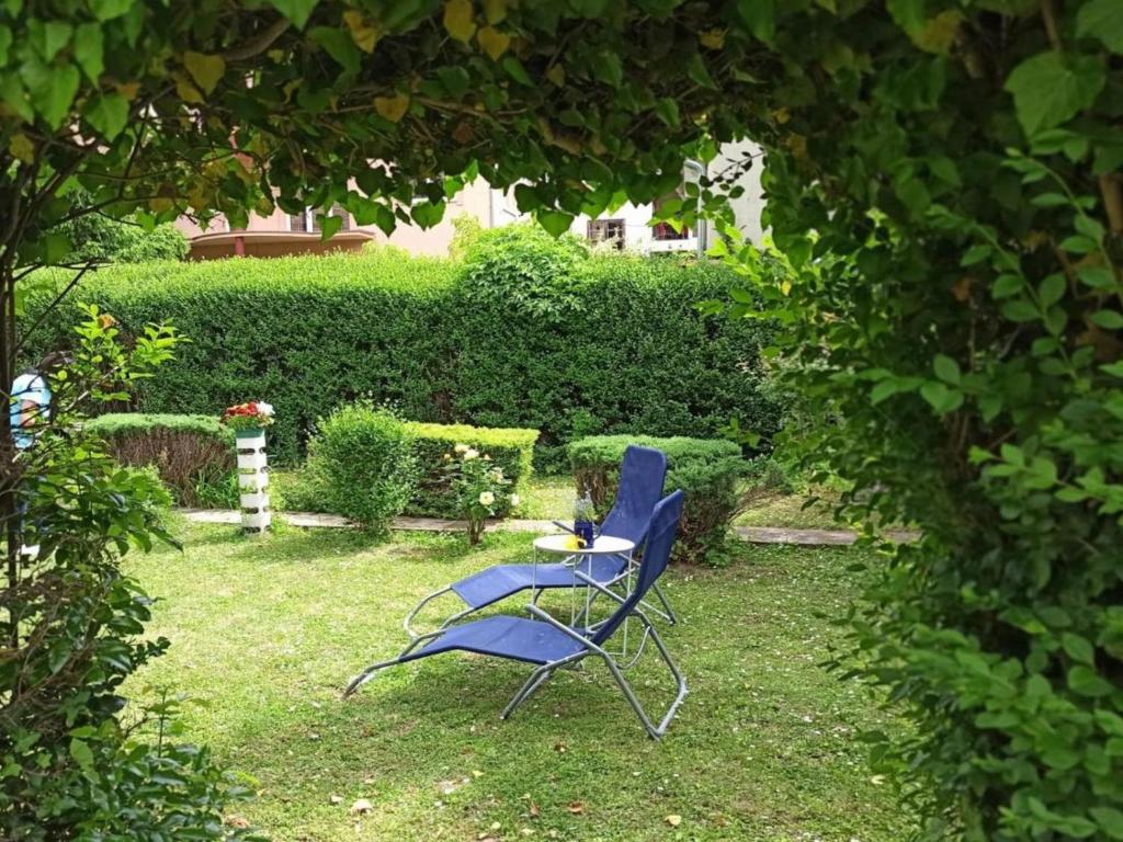 uma cadeira azul sentada na relva num jardim em Cocic Garden em Osijek