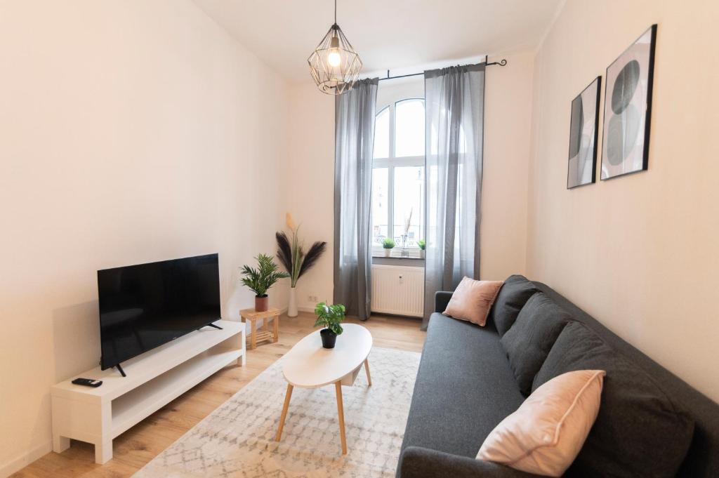 ein Wohnzimmer mit einem Sofa und einem TV in der Unterkunft DWELLSTAY - Premium Wohnung I 95qm I 3 Schlafzimmer I großes Bad I Küche I Wohnzimmer I TV in Fulda