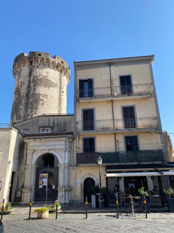 un bâtiment avec une tour à côté d'un bâtiment dans l'établissement Holiday House Ginevra, à Formia
