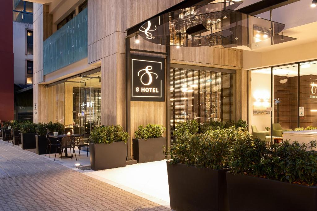 S Hotel Boutique Thessaloniki في سلانيك: يوجد متجر للنباتات الفخارية أمام المبنى