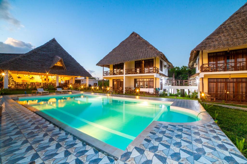 une image d'une piscine en face d'une maison dans l'établissement Mahi Mahi Beach Hotel, à Jambiani