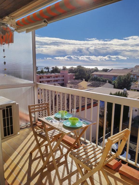 stół i krzesła na balkonie z widokiem w obiekcie Studio Tout à Pied - Vue Sur Mer w mieście Saint-Aygulf