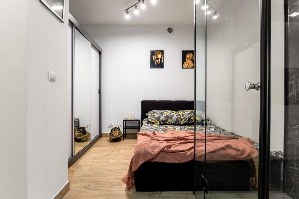 - une chambre avec un lit et un miroir dans l'établissement Wyjątkowy apartament z prysznicem pośrodku na wyjątkowe wieczory NAD JASIENIEM 39 Łódź, à Łódź