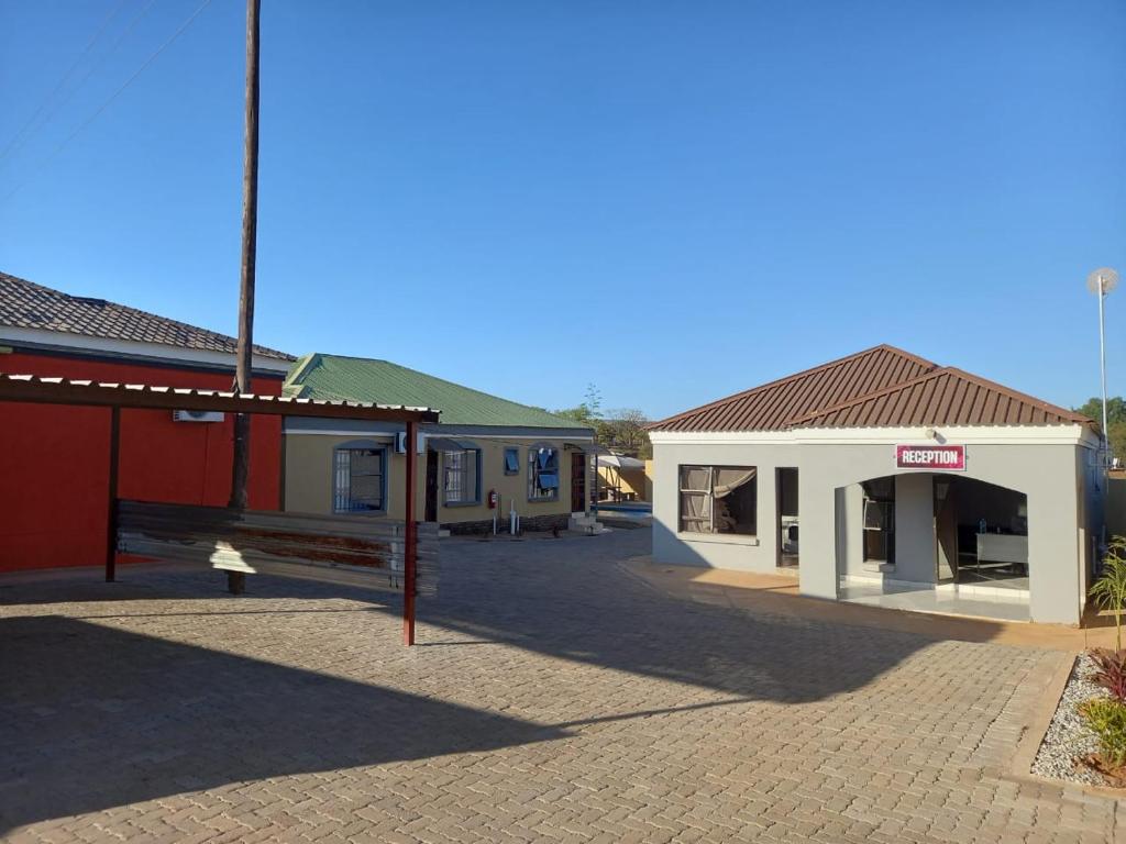an empty parking lot in front of two buildings at Kgakgamela road lodge in Driekop
