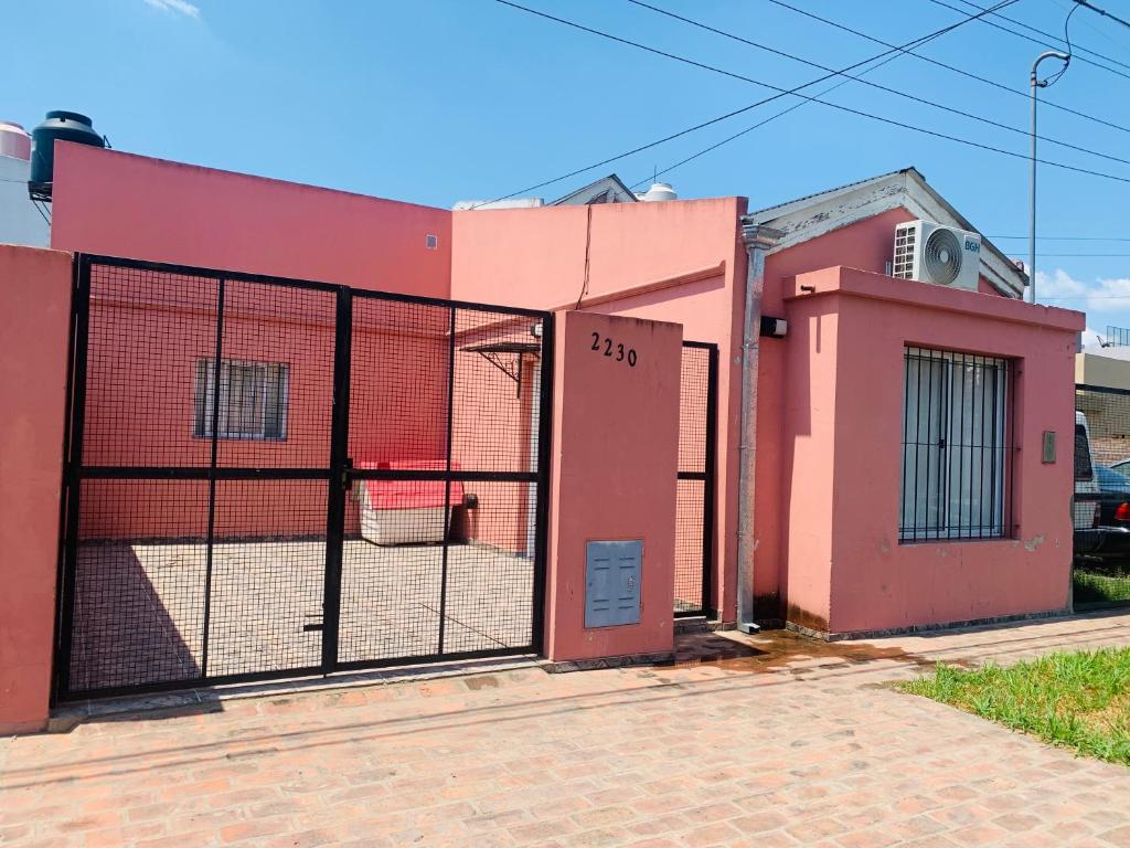 une clôture devant un bâtiment rose dans l'établissement Casa en San Pedro, à San Pedro