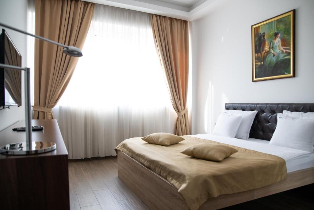 波德戈里察的住宿－Motel Celebic，一间卧室设有一张大床和一个窗户。