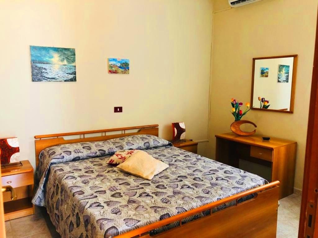 una camera con un letto e due comodini di Casetta del sole a Lampedusa