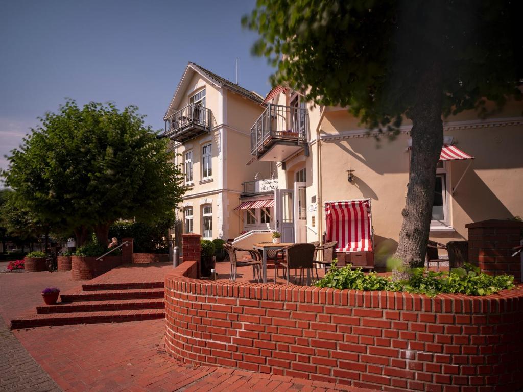 a brick wall with a table and chairs in front of a building at Sonnenresort Hüttmann in Norddorf