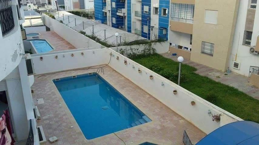eine Draufsicht auf einen Swimmingpool auf einem Gebäude in der Unterkunft Yasmine appartement A7 in Nabeul