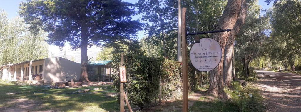 ein Schild vor einem Baum mit einem Gebäude in der Unterkunft Tiempo de Bienestar in Potrerillos