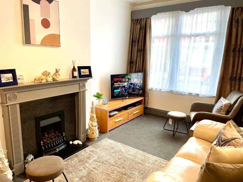 a living room with a fireplace and a television at Entire holiday home in Blackpool with free parking and a private patio garden in Blackpool
