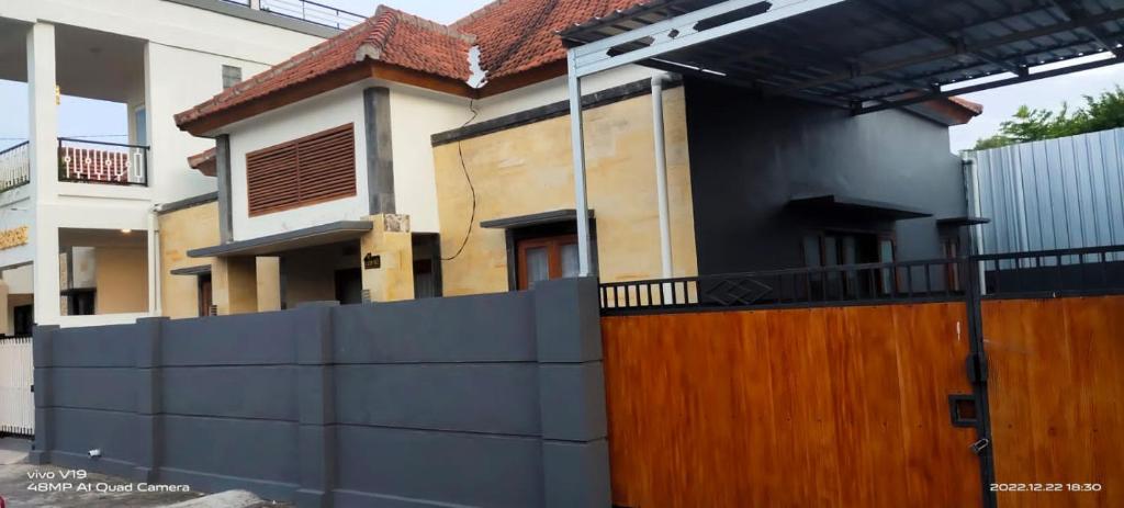una casa con una valla delante de ella en Juicezzy Home Fully Furnished 3 BR Guest House, en Singaraja