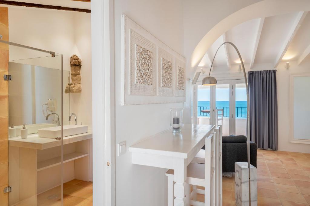 a white bathroom with a sink and a mirror at Porta Nova Suites - Room Breakfast & Sea View in Altea
