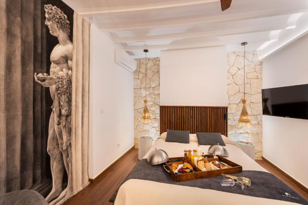 ein Schlafzimmer mit einem Bett und einem Tablett mit Essen drauf in der Unterkunft Porta Nova Suites Altea - Adults Only in Altea