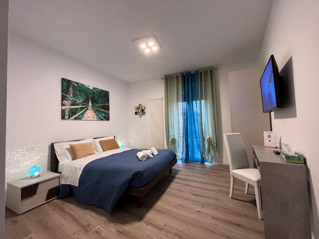 een slaapkamer met een bed, een bureau en een televisie bij verona rooms 109 in Verona