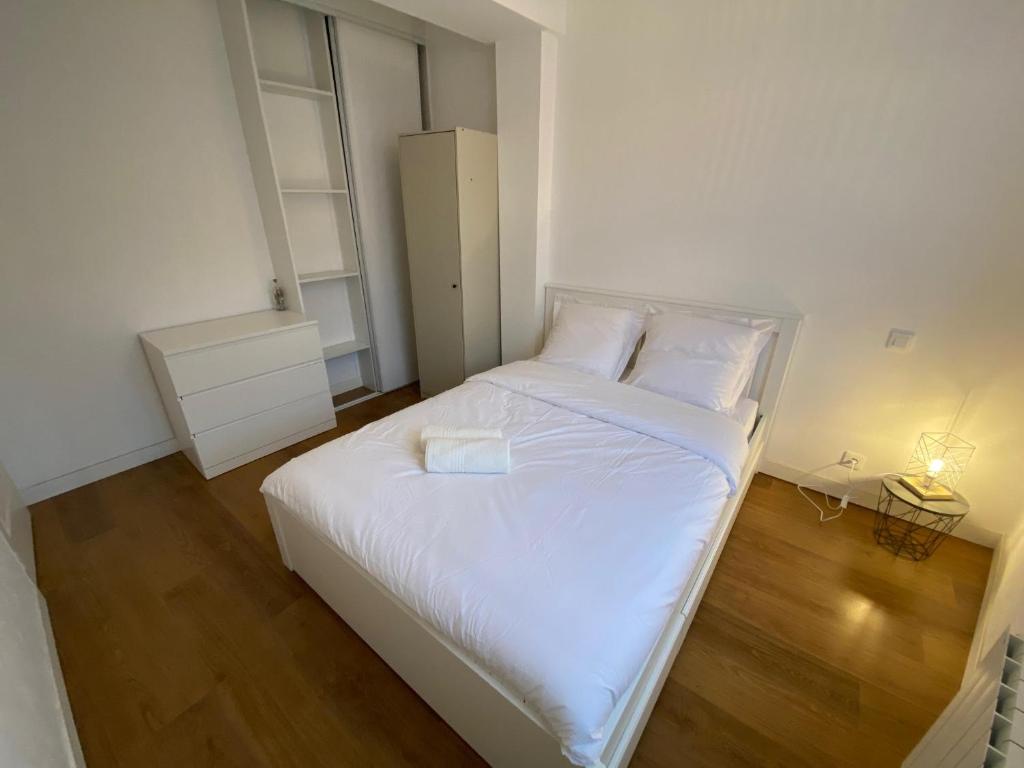 a small bedroom with a white bed with a night stand at LE PERCHOIR-POITIERS-LaConciergerie in Poitiers