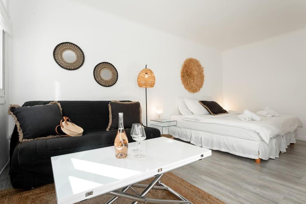 a living room with a black couch and a white table at Tulum - Centre Cannes - 100M plage - Calme - Wifi - Clim in Cannes