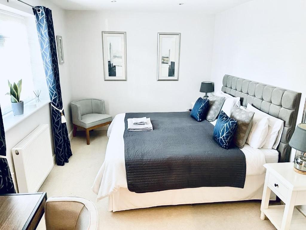 a bedroom with a large bed with blue pillows at The Thorpe Guesthouse in Huntingdon