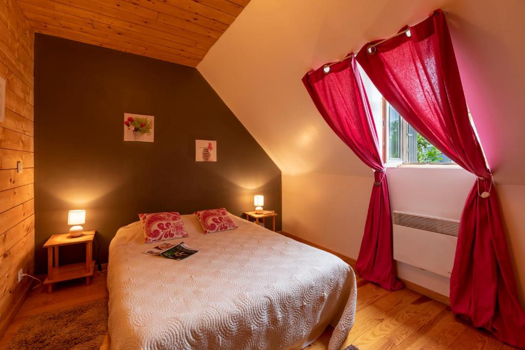 Schlafzimmer mit einem Bett mit roten Vorhängen und einem Fenster in der Unterkunft Le Gentil Home Chambres d'Hôtes in Arras-en-Lavedan