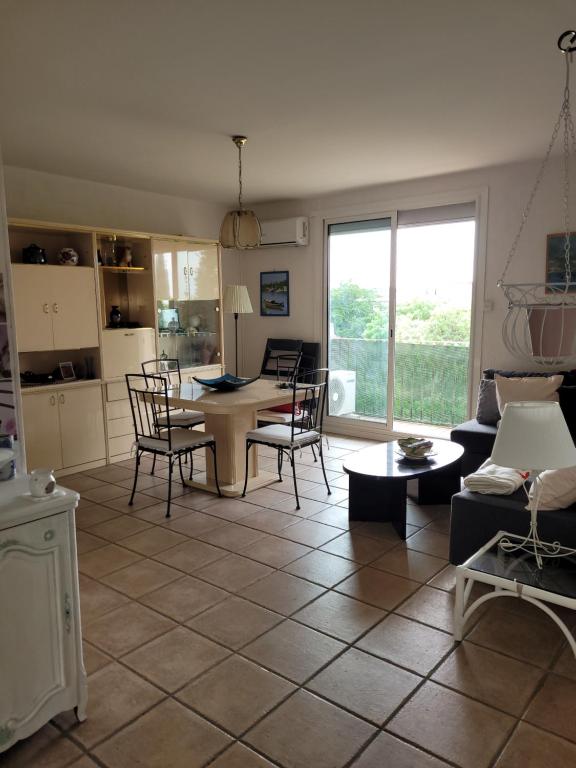 a living room with a table and chairs and a kitchen at Appartement 7 couchages in Salon-de-Provence