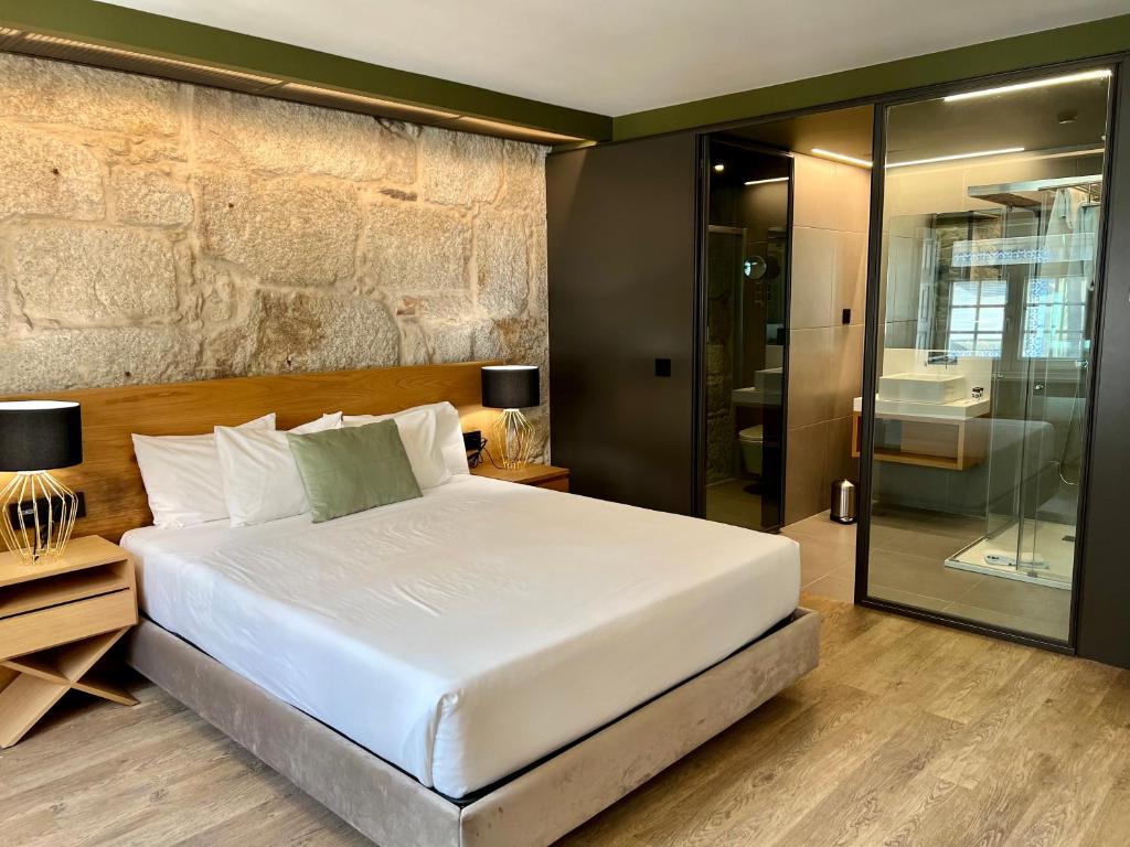 een slaapkamer met een groot wit bed en een douche bij Oca Ribeira do Porto AT in Porto