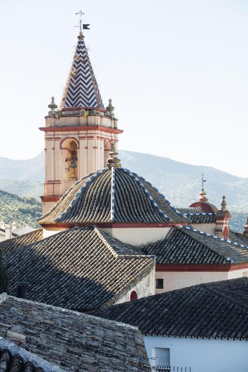 a building with a tower with a cross on its roof at Hotel Tugasa Arco de la Villa in Zahara de la Sierra