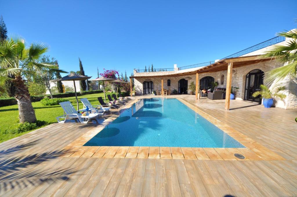 een zwembad met stoelen en een huis bij Villa Dar Sultana in Essaouira