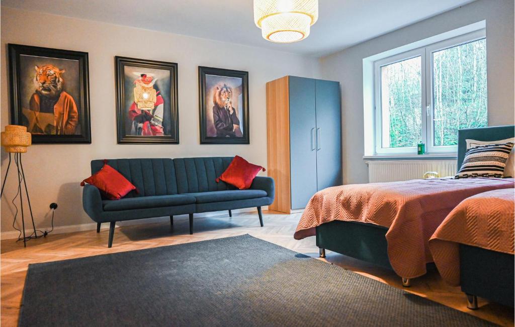 una camera con un divano blu e un letto di Awesome Apartment In Stezyca With Sauna a Stężyca