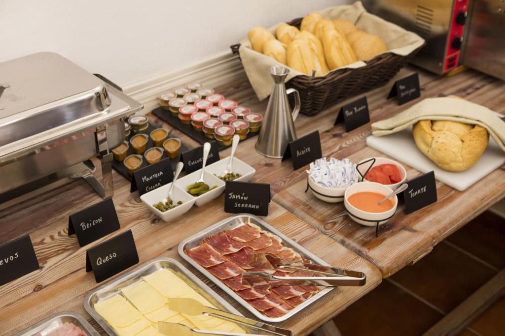 a table with different types of food on it at Hotel Tugasa Arco de la Villa in Zahara de la Sierra