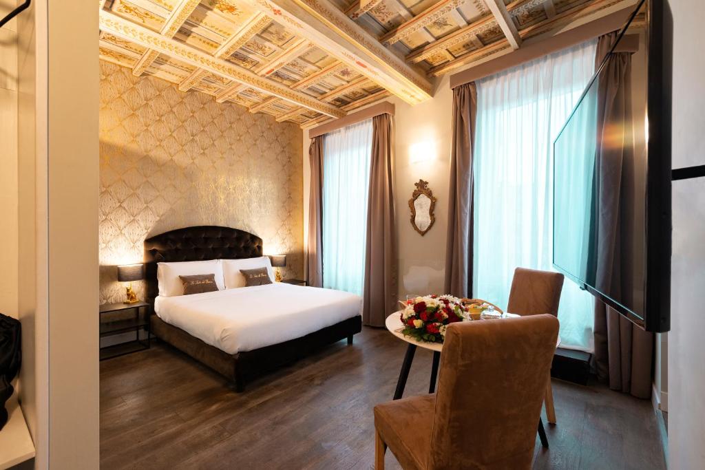 ローマにあるLe Suite del Baroneのホテルルーム(ベッド1台、テーブル、フルーツボウル付)