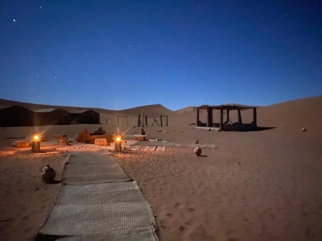 a tent in the middle of a desert at night at Erg Chegaga Desert Night in El Gouera