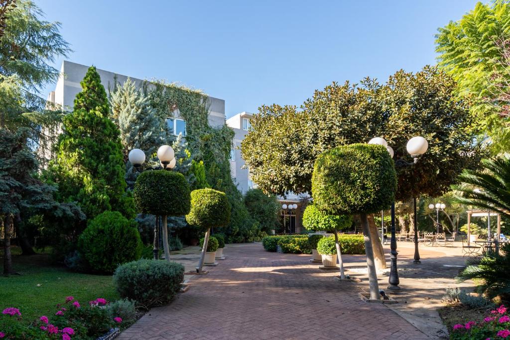 un jardín con árboles, arbustos y luces de la calle en Hotel Checkin Valencia Ciscar, en Picaña