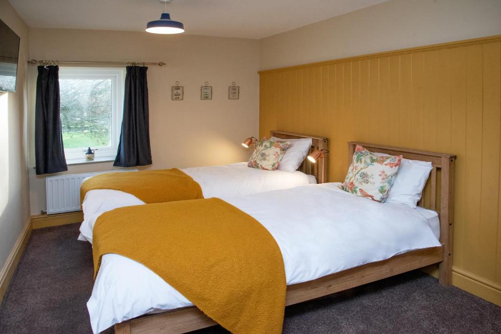 two beds in a room with yellow walls at Stay Northside - Luxury Corporate & Holiday Stays, County Durham 